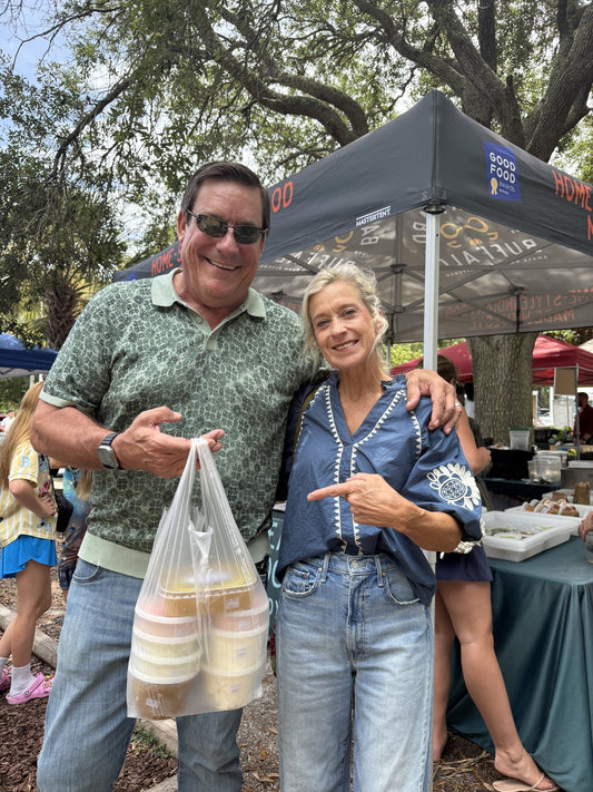 Two customers at the Backyard Buffalo tent holding a bag of meals