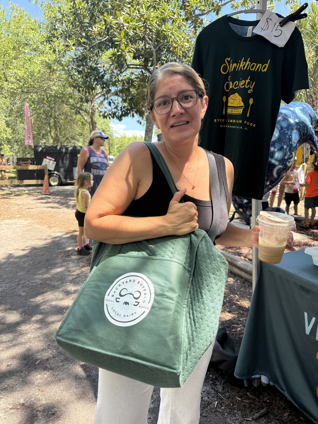 A customer at the Backyard Buffalo tent holding a Backyard Buffalo tote bag