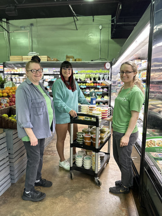 The Grassroots Natural Market crew stocking Backyard Buffalo meals into the cooler case